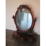 A Victorian mahogany oval dressing mirror with swivel shaped base with small opening to centre, 92cm