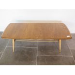 An Ercol light elm coffee table with rack, 37cm x 105cm x 43cm, some marks consistent with use but