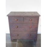 A dark wood four drawer chest with chiselled Adzed finish - Height 100cm x 101cm x 54cm