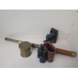 A three pull brass telescope, a pair of standard binoculars, a bellows camera and a trench art shell