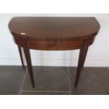 A 19th century demi lune mahogany foldover card table on square tapering legs, 75cm tall x 92cm wide