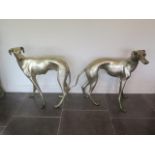 A pair of silvered metal life size greyhound dogs, 77cm tall x 87cm long, generally good some
