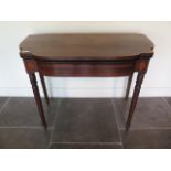 A 19th century mahogany foldover card table with a shaped top on turned legs, 76cm tall x 96cm wide,