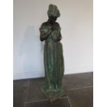 A bronze of a young lady holding a young bird in her dress signed A De luca, standing on a marble