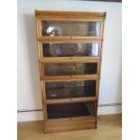 A light oak five section stacking Globe Wernicke bookcase with base and top and two internal book