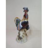 A late 19th / early 20th century porcelain model of a cockerel on a wheat stack, indistinct