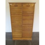 An oak double tambour fronted cabinet with a key, 151cm tall x 87cm x 38cm, tambour runs well,