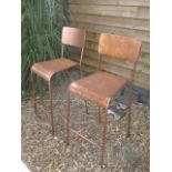 A pair of weathered metal bar stools