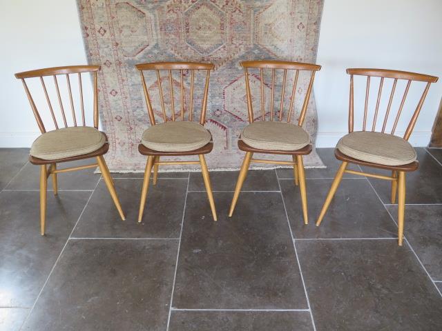 A set of four Ercol light elm seated kitchen chairs with cushions, 82cm tall all in useable