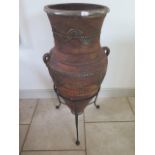 A Moroccan metal decorated terracotta amphora on stand, 116cm tall, top measures 44cm diameter, in