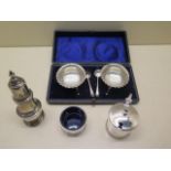A boxed two piece silver salt, a silver pepper, mustard and salt with glass liners, silver weight