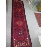 A hand woven vintage Persian Heriz runner with medallion design in vibrant colours, 310cm x 83cm