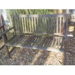 A weathered wooden garden bench, 130cm wide