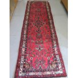 A full pile red ground hand knotted Persian Hamadan runner floral design 315cm x 100cm in good