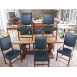 An oak refectory table on carved bulbous supports with 8 green leather upholstered chairs, 76cm tall