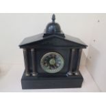 A Victorian black slate striking mantle clock in running order, chip to one corner otherwise