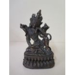 A bronze seated diety with gilt and red patinated finish, 20cm tall