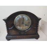 An 8 day oak vased mantle clock, 29cm tall x 33cm wide, generally good running, some wear to dial