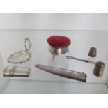 A collection of small silver items, caddy spoon, heart shaped pin cushion, two silver thimbles, a