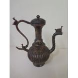 A gilt and red metal lidded Islamic coffee pot, 24cm tall with a patinated finish