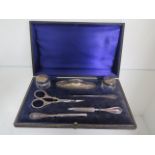 A boxed silver and steel seven piece manicure set, some small dents and scissors have been