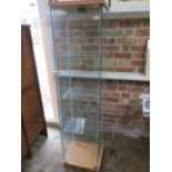 A glass display cabinet with electric lighting, 164cm tall x 43cm x 37cm