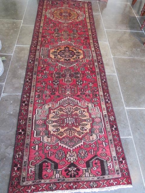 A hand knotted woollen runner rug, 290cm x 88cm, generally good condition