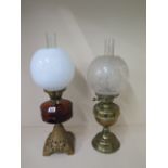 Two oil lamps with globe shades, 56cm tall, both generally good, brass one has a small dent, wicks