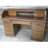 An oak roll top desk with a fitted interior over eight drawers and two slides, 104cm tall x 153cm