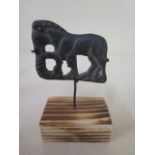 A metal figure on stand, 8cm tall, with patinated finish