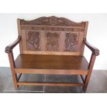 A well carved oak bench hall settle, dated 1928, 106cm tall x 113cm x 55cm, in good condition with a