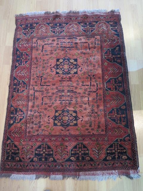 A hand knotted woollen rug, slight wear but generally good, 155cm x 104cm