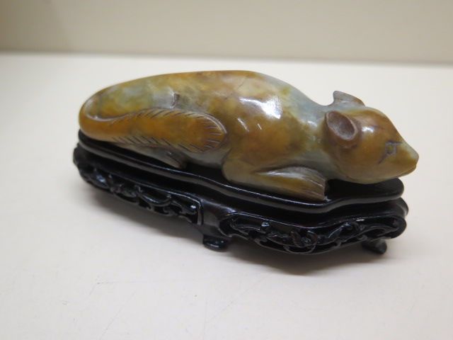 A carved jade celadon and russet tree squirrel on a carved base, 5cm tall x 10cm x 4cm wide, in good