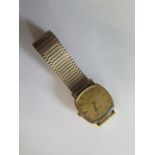 A hallmarked 9ct yellow gold Bulova quartz date wristwatch, 30mm wide on a plated strap, in