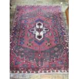 A washed red ground full pile hand woven Persian village rug, 210cm x 155cm, in good condition