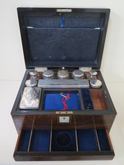 A Victorian walnut travel box with a fitted interior containing nine bottles and tidies with
