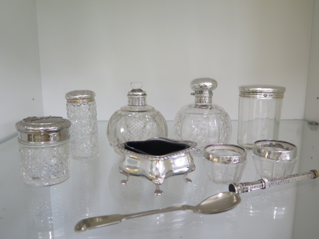 Four silver top bottles, a silver plated powder bottle, two silver rim glass salts, a silver