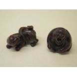 Two carved wooden Netsukes of a lion and serpent, 4.5cm tall and a seated figure 3.5cm tall, both