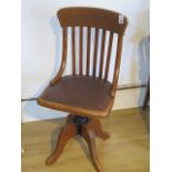 An oak 1930's revolving desk chair with a padded seat, good condition
