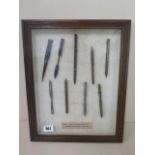 A framed display of 9 WWI Ariel darts-Flechettes