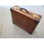 A Vintage fibre and leather suitcase with brass locks in good polished usable condition, 19cm x 56cm