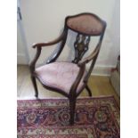 An Edwardian open armchair with padded seat and back