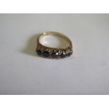 A hallmarked 9ct yellow gold five stone ring, possibly dark sapphires, size O, in good condition