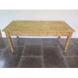 A Victorian style stripped pine kitchen table on turned legs, 76cm tall x 183cm x 83cm