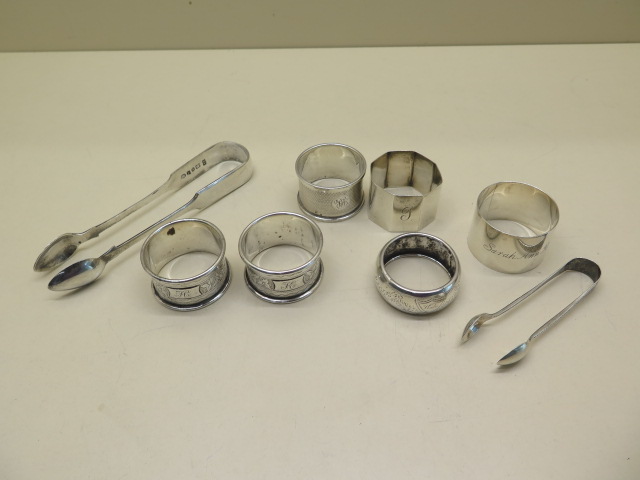 Six assorted silver napkin rings and two silver nips, approx 5.8 troy oz