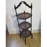 A three tier mahogany and cane cake stand, 92cm tall, in good condition