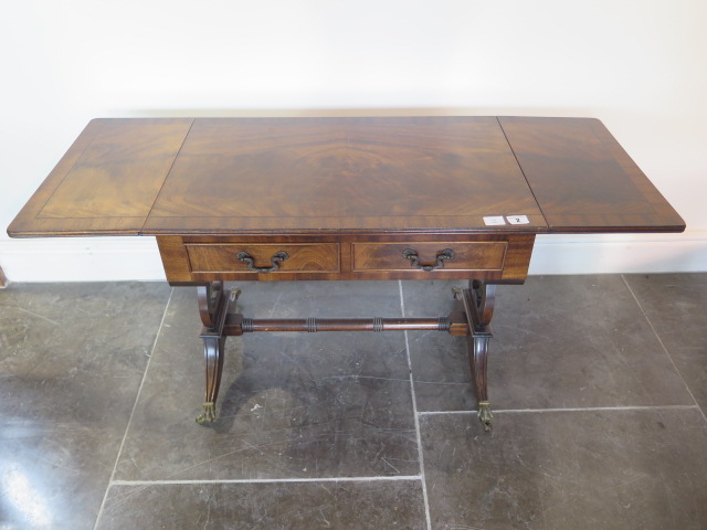 A mahogany dropleaf coffee table with two small drawers, 51cm tall x 129cm extended by 41cm