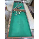 A Victorian mahogany folding table top Bagatelle game with 12 ivory balls 3.5cm diameter and 5cm