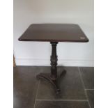 An early 19th century oak side table on a carved turned column and tripartite platform base, 74cm