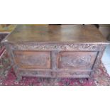 An antique carved oak coffer mule chest converted to a two door cupboard, 69cm tall x 125cm x